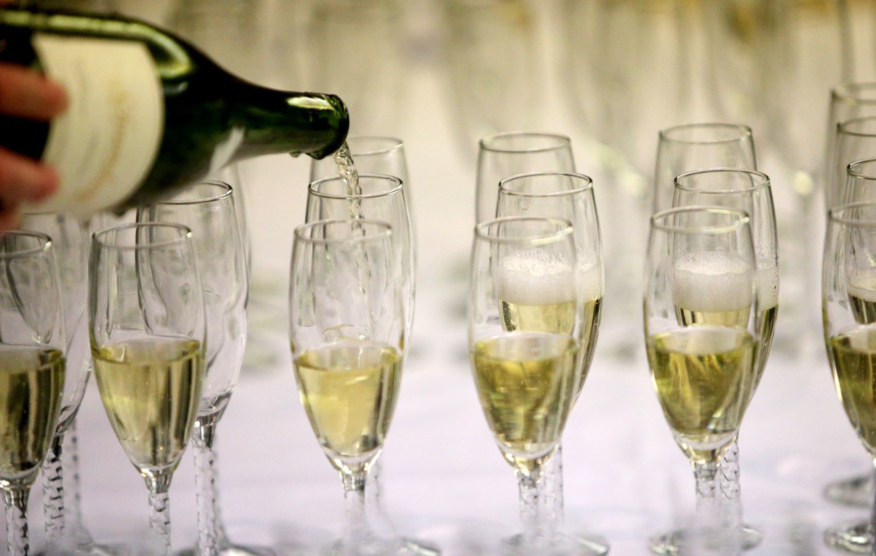 A volunteer pours sparkling wine